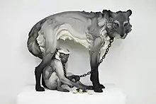 Title: "Tribute" from the exhibition "The Other" Year: 2017 Dimensions: Wolf: 58 in. length, 46 in. height, 31 in. width Materials: Stoneware, paint, hand-forged steel collars and chain