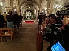 A smaller DLSR camera with a rig shooting a church wedding
