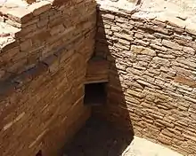 A color picture of a corner doorway in a large sandstone wall