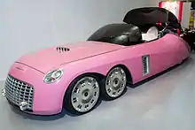 A six-wheeled car with tinted glass canopy, in a car museum