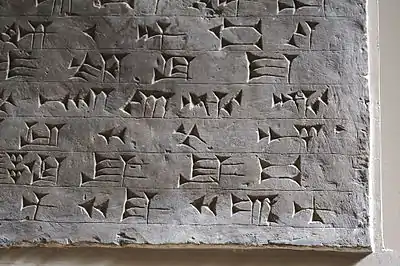 Photo taken at British Museum. (bi, 2nd line from bottom)Note: the 2nd from last character, 1st line is based on the "bi" cuneiform sign (wedge-stroke added at beginning, but often between the two horizontals), the sign for ṣur (AMAR (cuneiform)), etc. (also sumerogram AMAR, for: "See!", or "Look!..." (Akkadian language amāru).