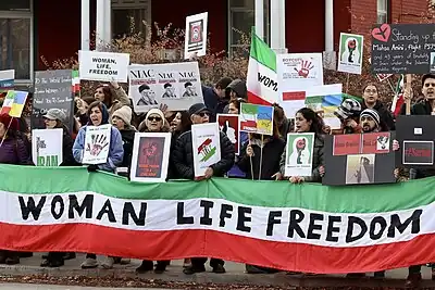 A sign with the slogan on it in Central and Northern Kurdish as well as English