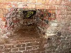 This large hole gives an idea how thick the brick lining is. Note survey marker.