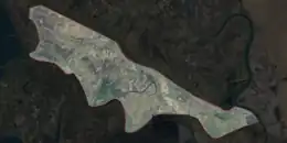 An aerial image of an island, outlined against other landforms.