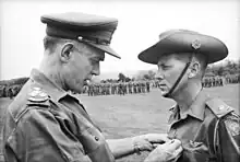 Major Harry Smith of St. John's Wood, Brisbane, Qld, receiving the ribbon to the Military Cross for gallantry from Brigadier O. D. Jackson.