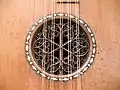 Baroque guitar soundhole with inserted wooden rose and inlaid rosette (1700).