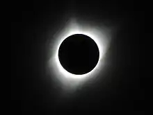 An image of a total solar eclipse at Orin Junction, Wyoming in 2017. A total solar eclipse happens when the Moon completely blocks the face of the Sun. It is the result of a cosmic coincidence. Even though the Sun is about 400 times bigger than the Moon, it is also about 400 times farther away. This makes the Sun and the Moon appear almost exactly the same size in our sky.