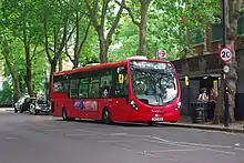 A single decker bus on Tower Transit route 236 surrounded by greenery.